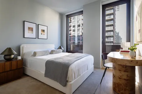 a bedroom with a bed a mirror and a window