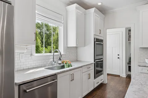 a kitchen with white cabinets and a stove
