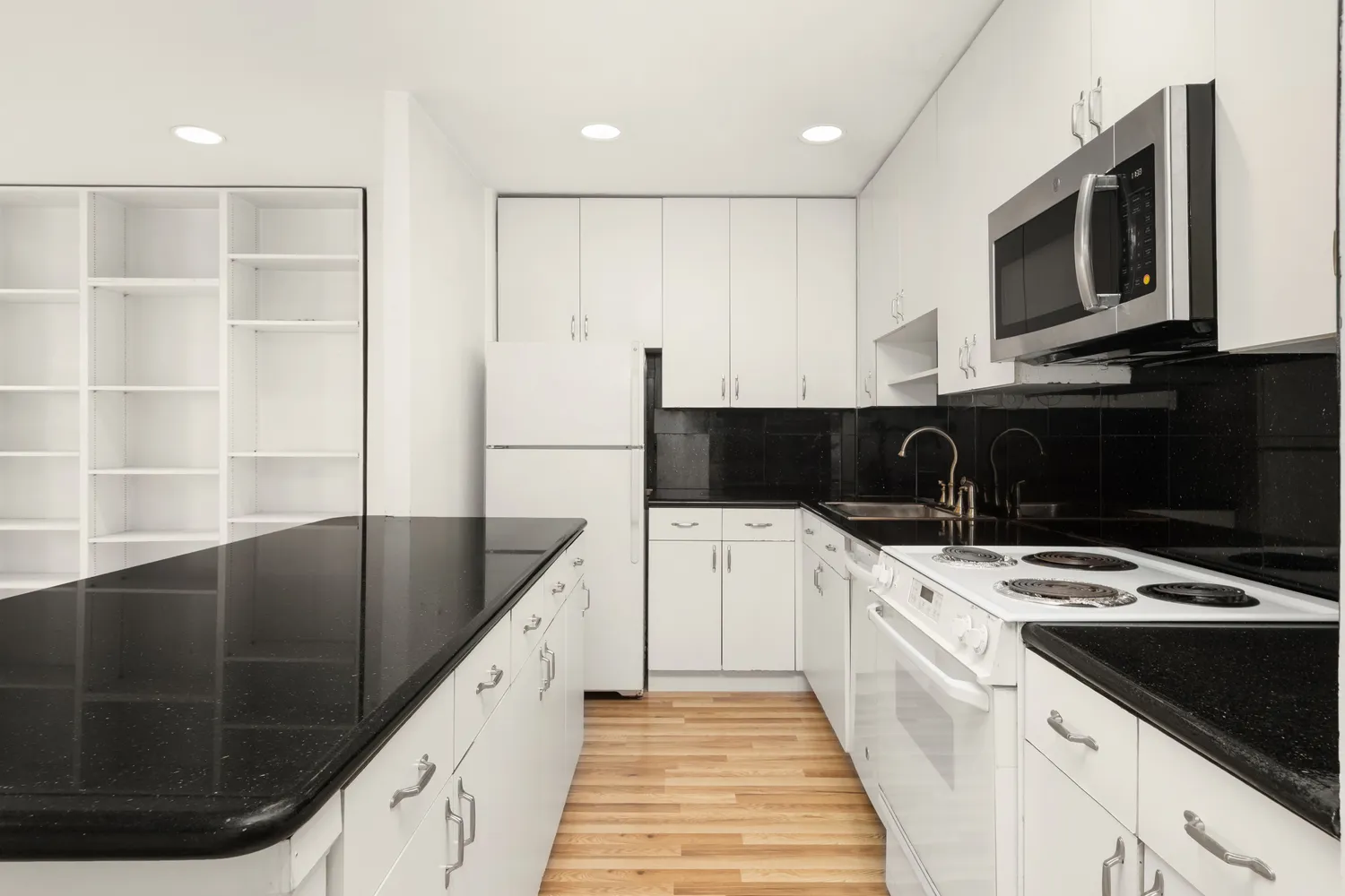 a kitchen with stainless steel appliances kitchen island granite countertop a stove a sink and a microwave