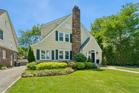 a view of a house with a yard and potted plants