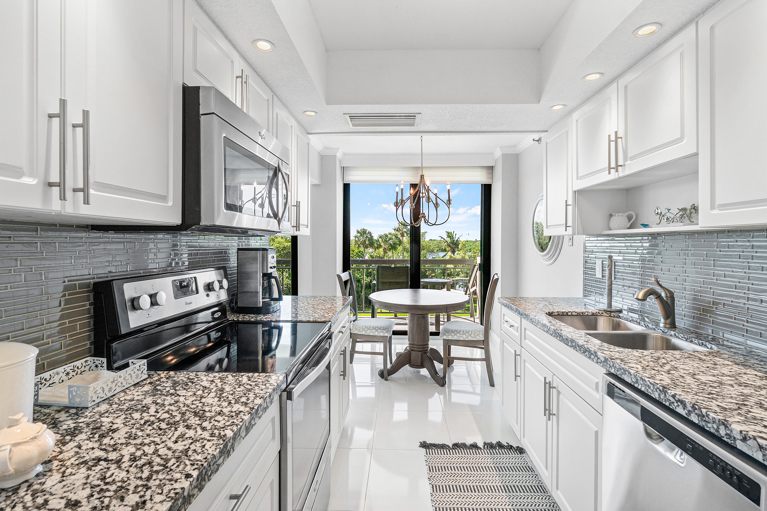 2003 North Ocean Boulevard, Unit 305 Boca Raton, FL 33431 - Photo 33 of 56 a kitchen with stainless steel appliances granite countertop a sink stove and cabinets