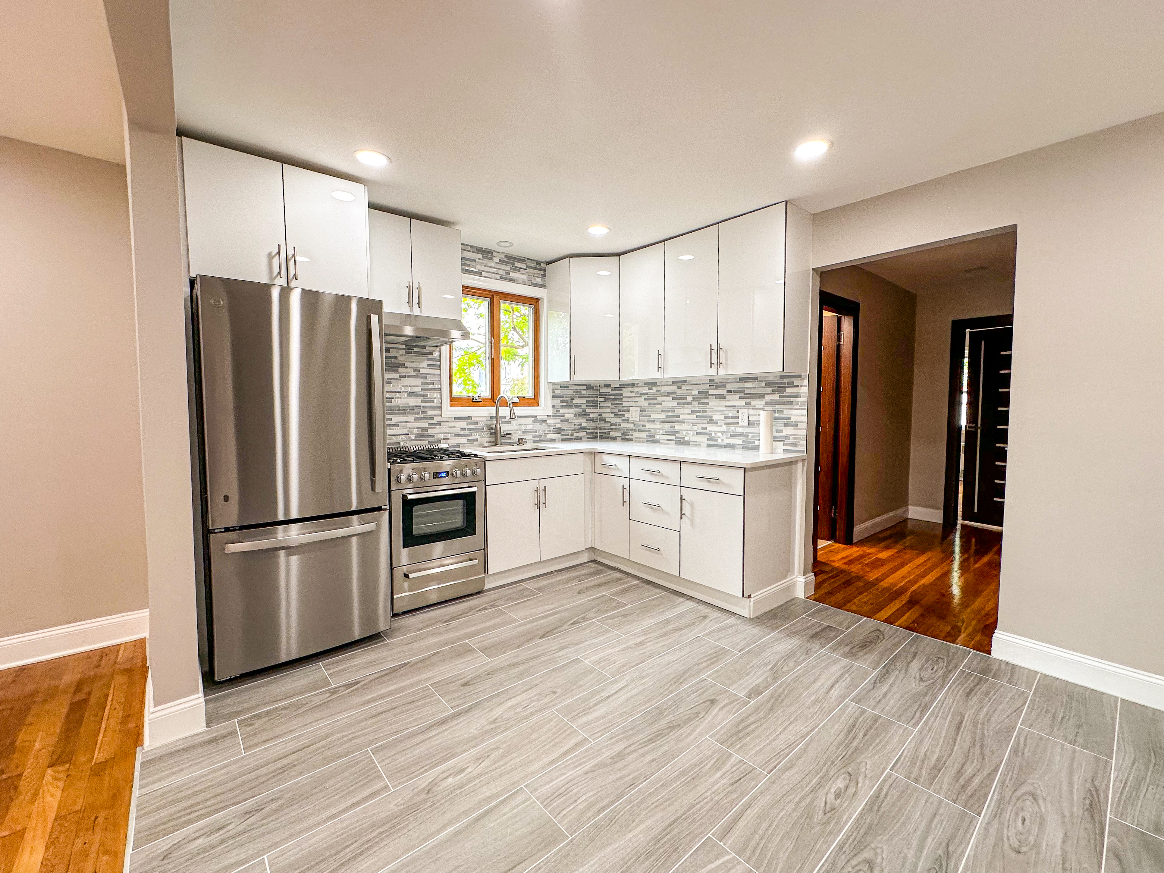 10-01 154th Street, Unit 1 Queens, NY 11357 - Photo 2 of 10 a kitchen with a refrigerator a stove top oven and kitchen island