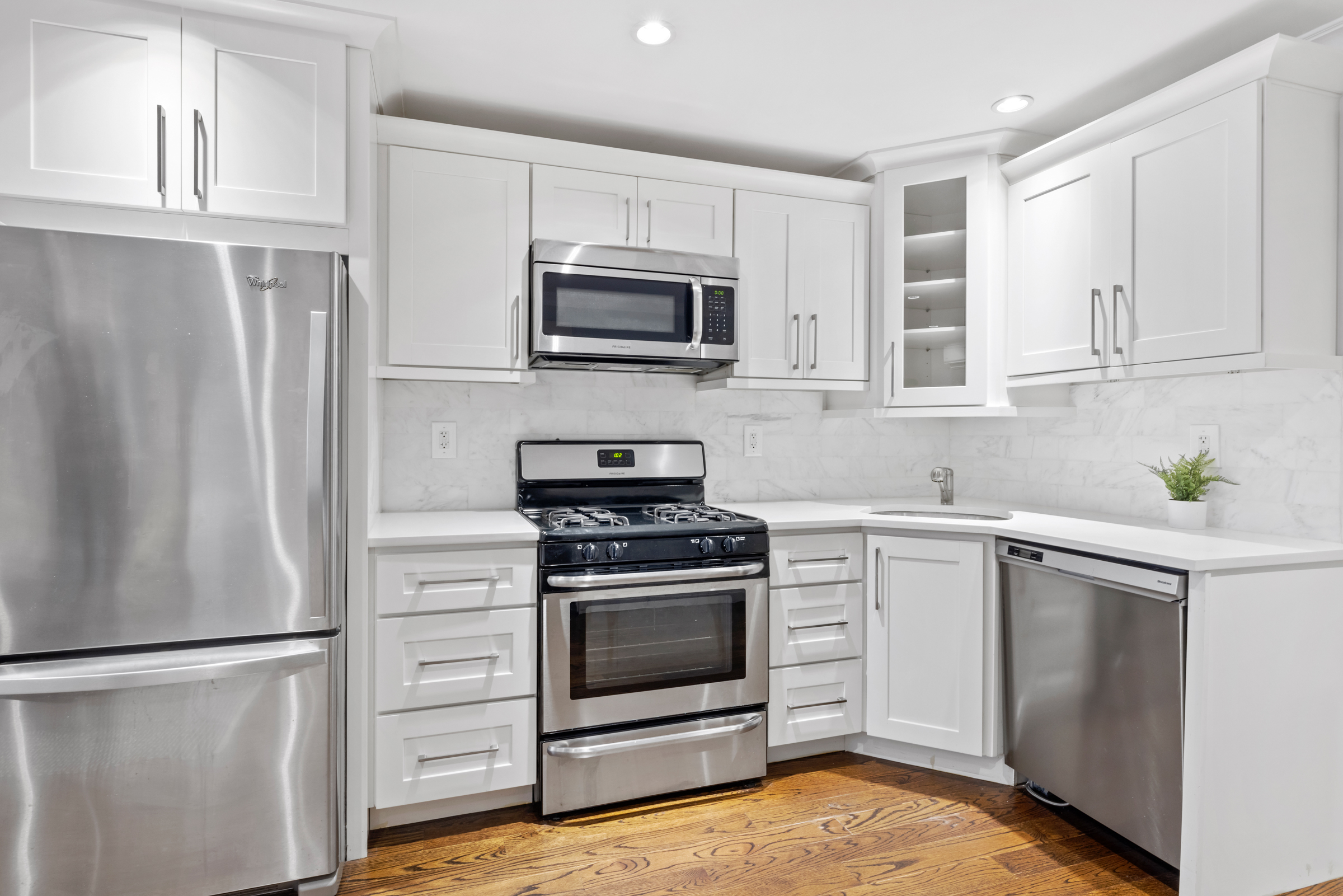 439 A Monroe Street Brooklyn, NY 11221 - Photo 19 of 29 a kitchen with stainless steel appliances white cabinets white stove a refrigerator and a microwave