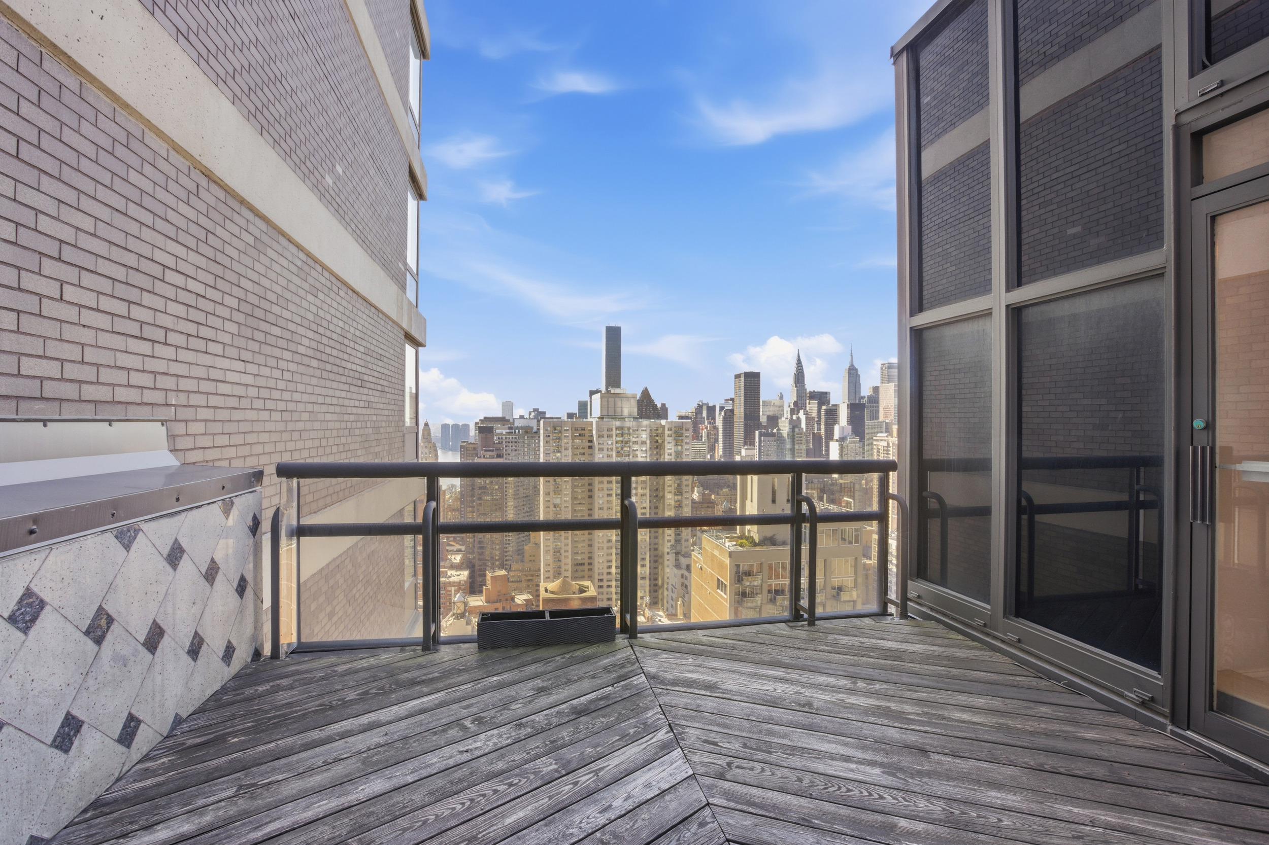 418 East 59th Street, Unit PHA Manhattan, NY 10022 - Photo 7 of 17 a view of a balcony with wooden floor and iron fence