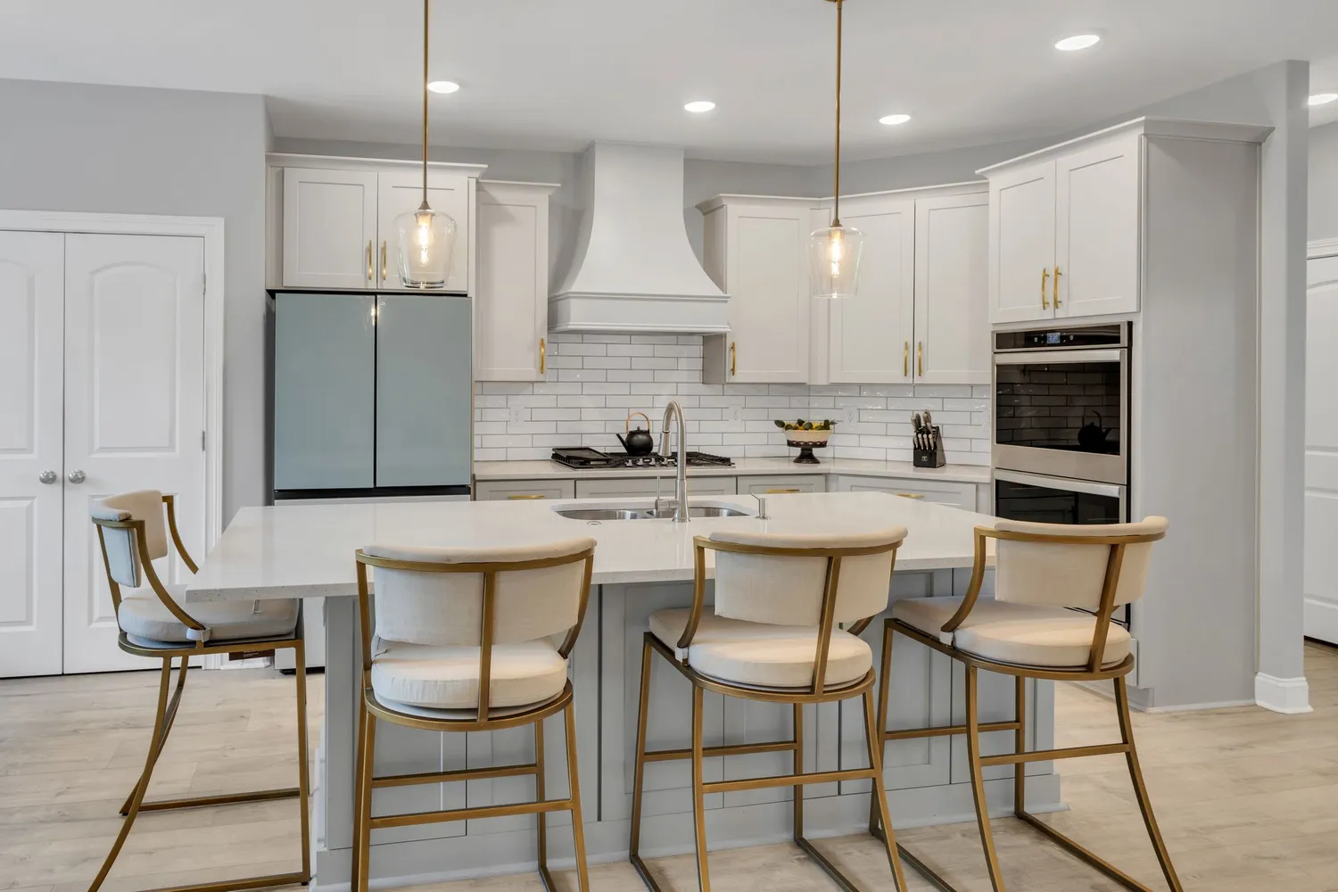 a kitchen with stainless steel appliances kitchen island granite countertop a dining table chairs and white cabinets