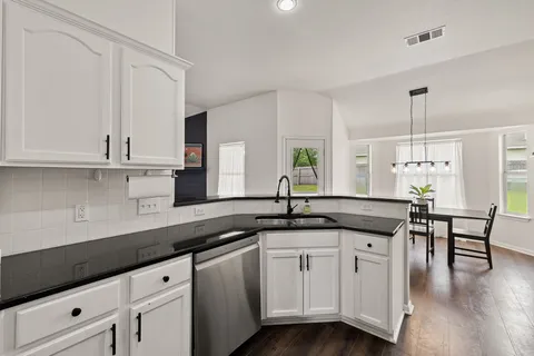 a kitchen with granite countertop a sink and cabinets