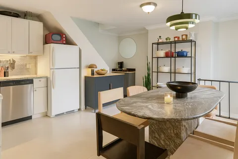 a kitchen with a table and a refrigerator