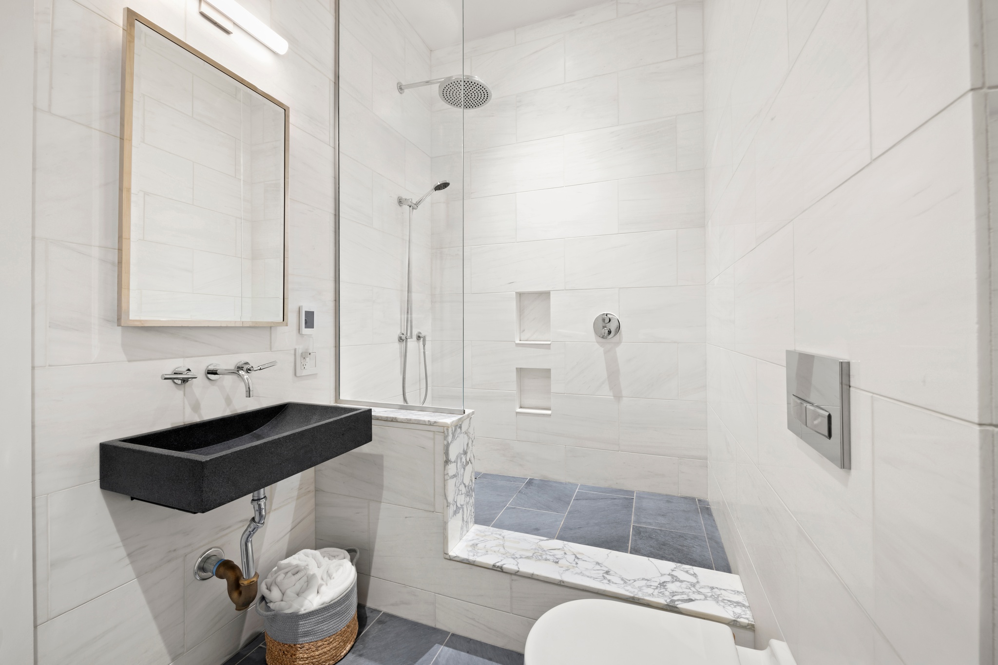 181 Hudson Street, Unit 2B Manhattan, NY 10013 - Photo 8 of 10 a bathroom with a sink a toilet and shower