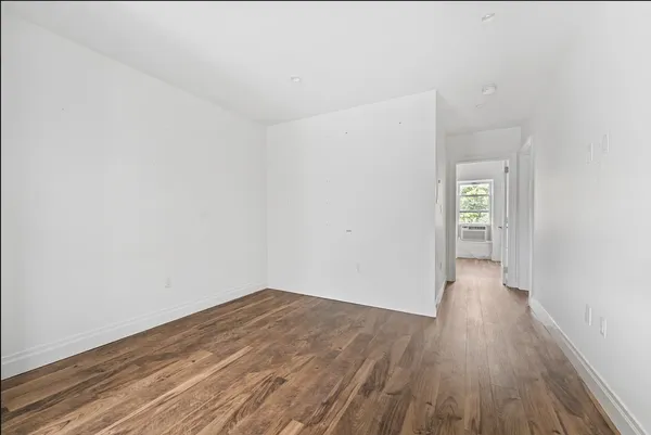 a view of a small space with wooden floor and a window