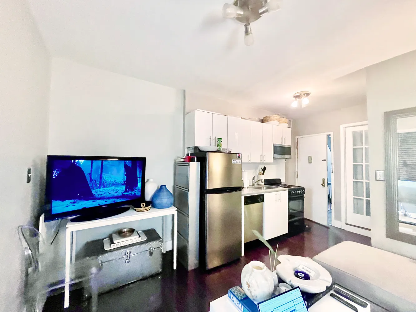 a kitchen with stainless steel appliances a stove a refrigerator and a wooden floor