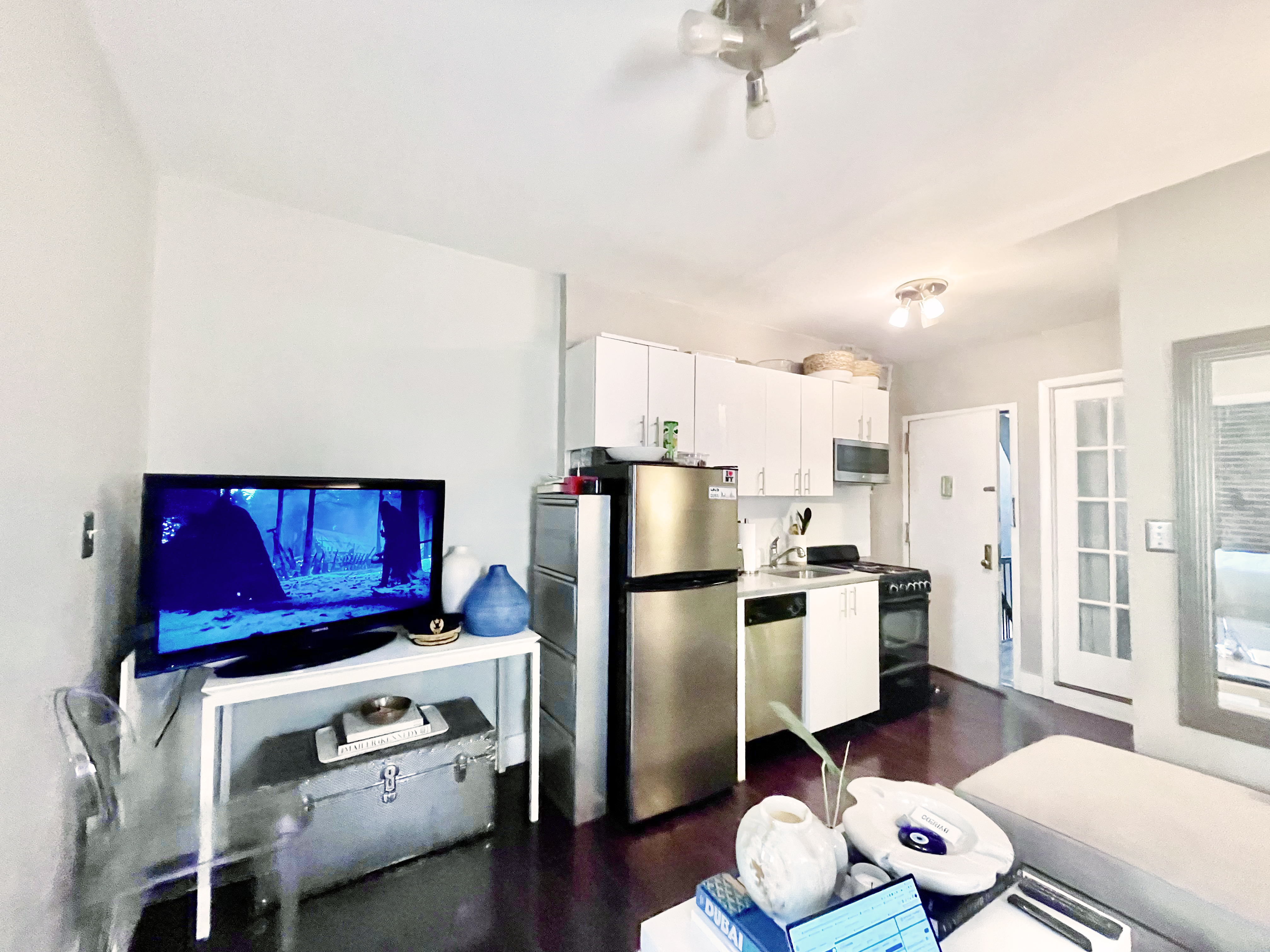 57 Spring Street, Unit 6 Manhattan, NY 10012 - Photo 9 of 10 a kitchen with stainless steel appliances a stove a refrigerator and a wooden floor