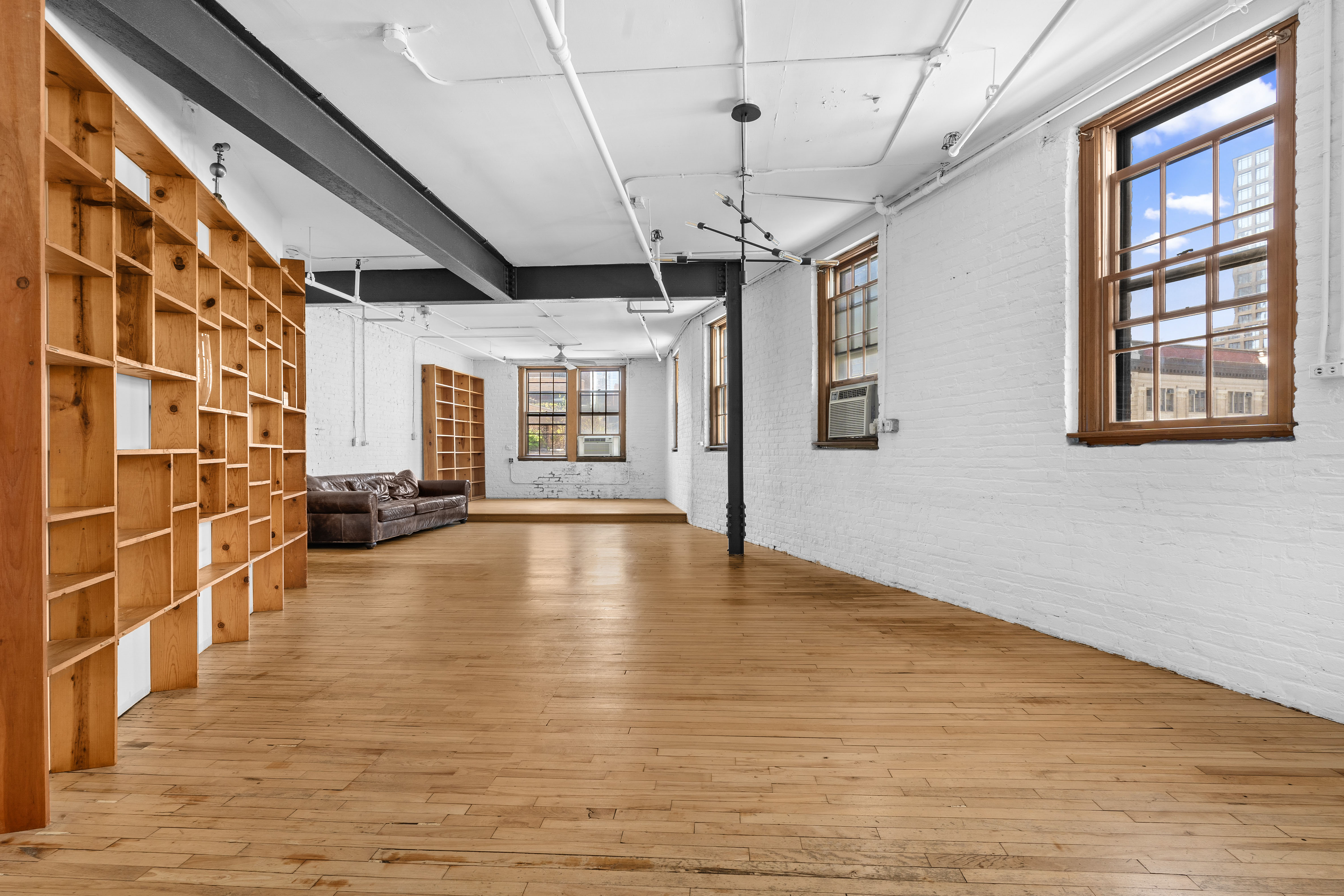 210 Spring Street, Unit 5 Manhattan, NY 10012 - Photo 1 of 10 a view of empty room with wooden floor and windows