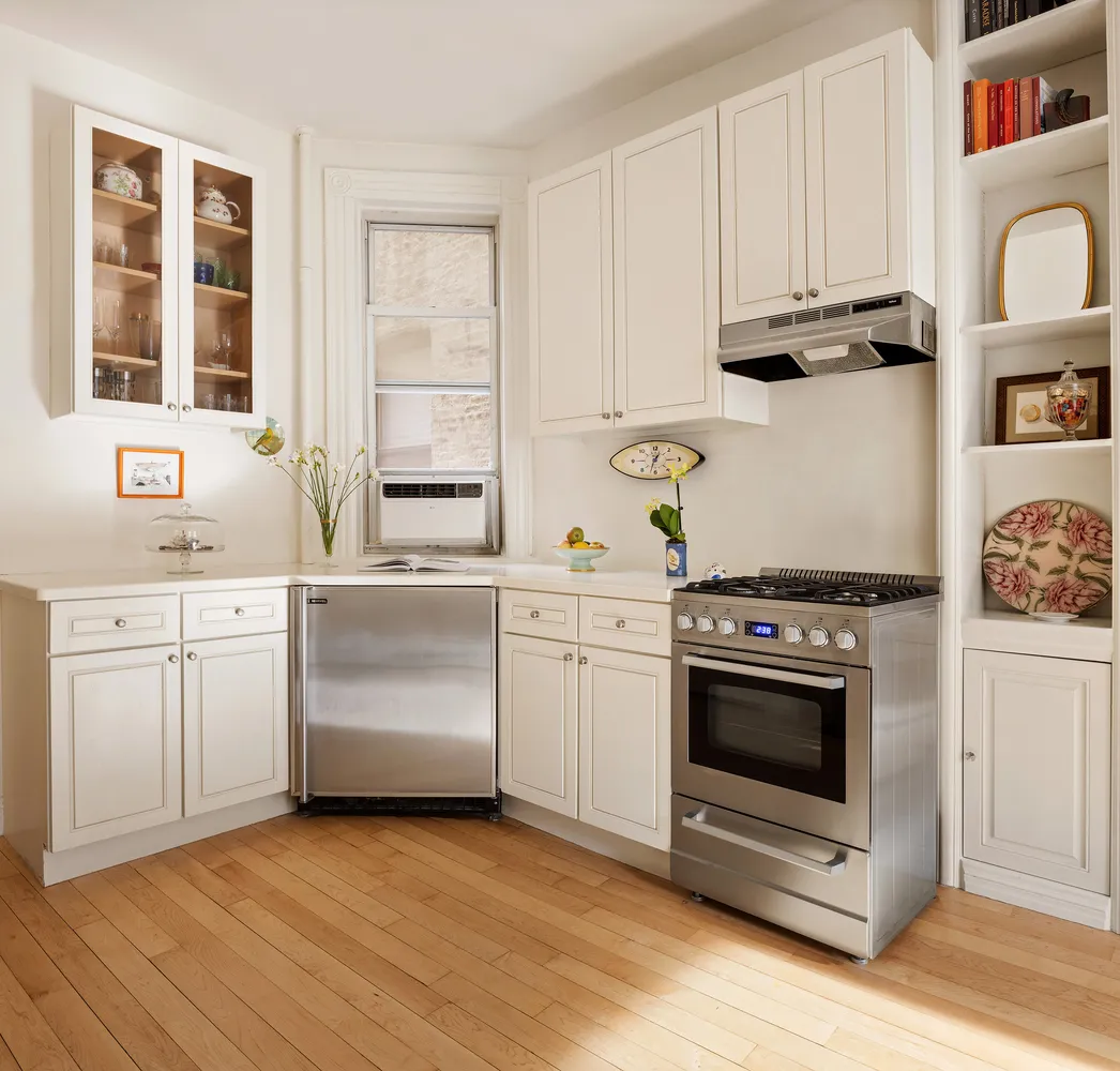 a kitchen with white cabinets and white appliances