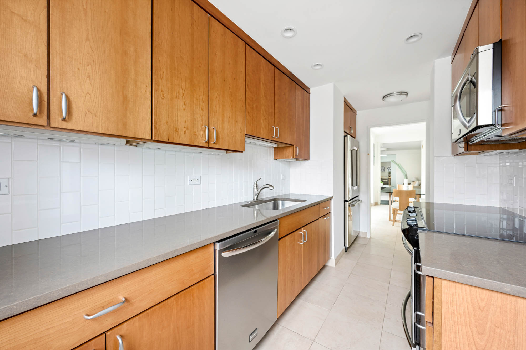 936 5th Avenue, Unit 10AB Manhattan, NY 10021 - Photo 25 of 37 a kitchen with stainless steel appliances granite countertop a sink and cabinets