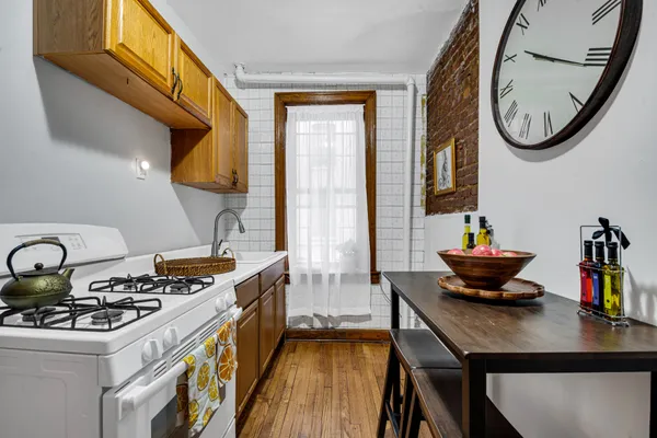 a kitchen with a stove a sink and a dining table