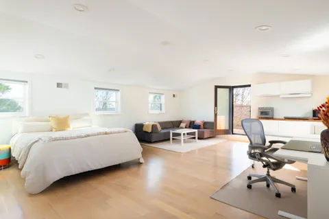 a spacious bedroom with a bed a table and chair