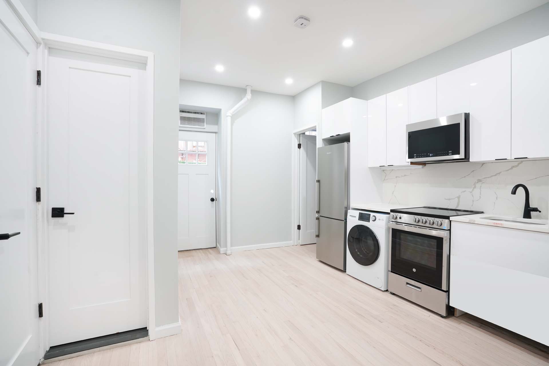 210 West 10th Street, Unit 1C Manhattan, NY 10014 - Photo 2 of 6 a view of a kitchen with stainless steel appliances kitchen island wooden floor and window