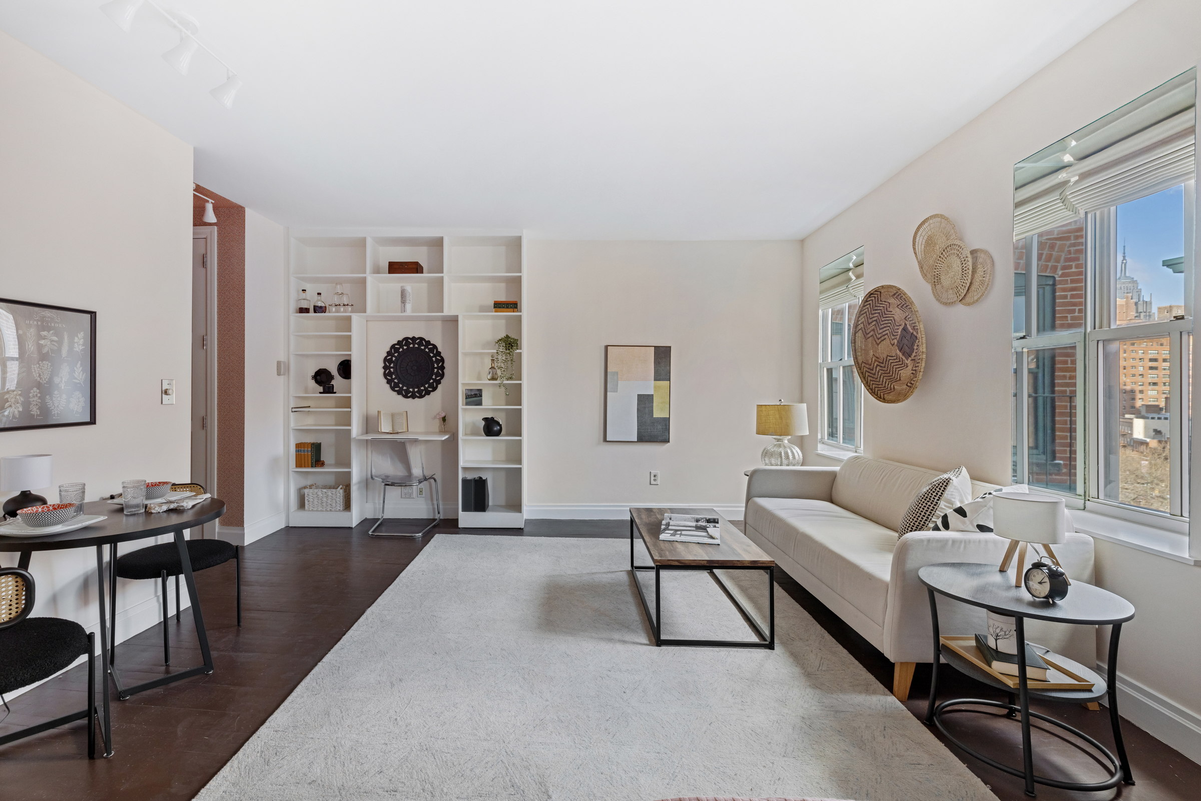 99 Bank Street, Unit 7E Manhattan, NY 10014 - Photo 2 of 8 a living room with furniture a clock on wall and a table
