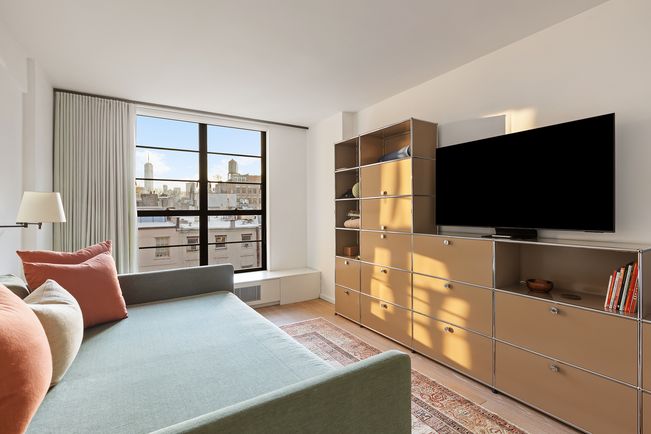 37 West 12th Street, Unit 7J Manhattan, NY 10011 - Photo 11 of 18 a living room with furniture and a flat screen tv