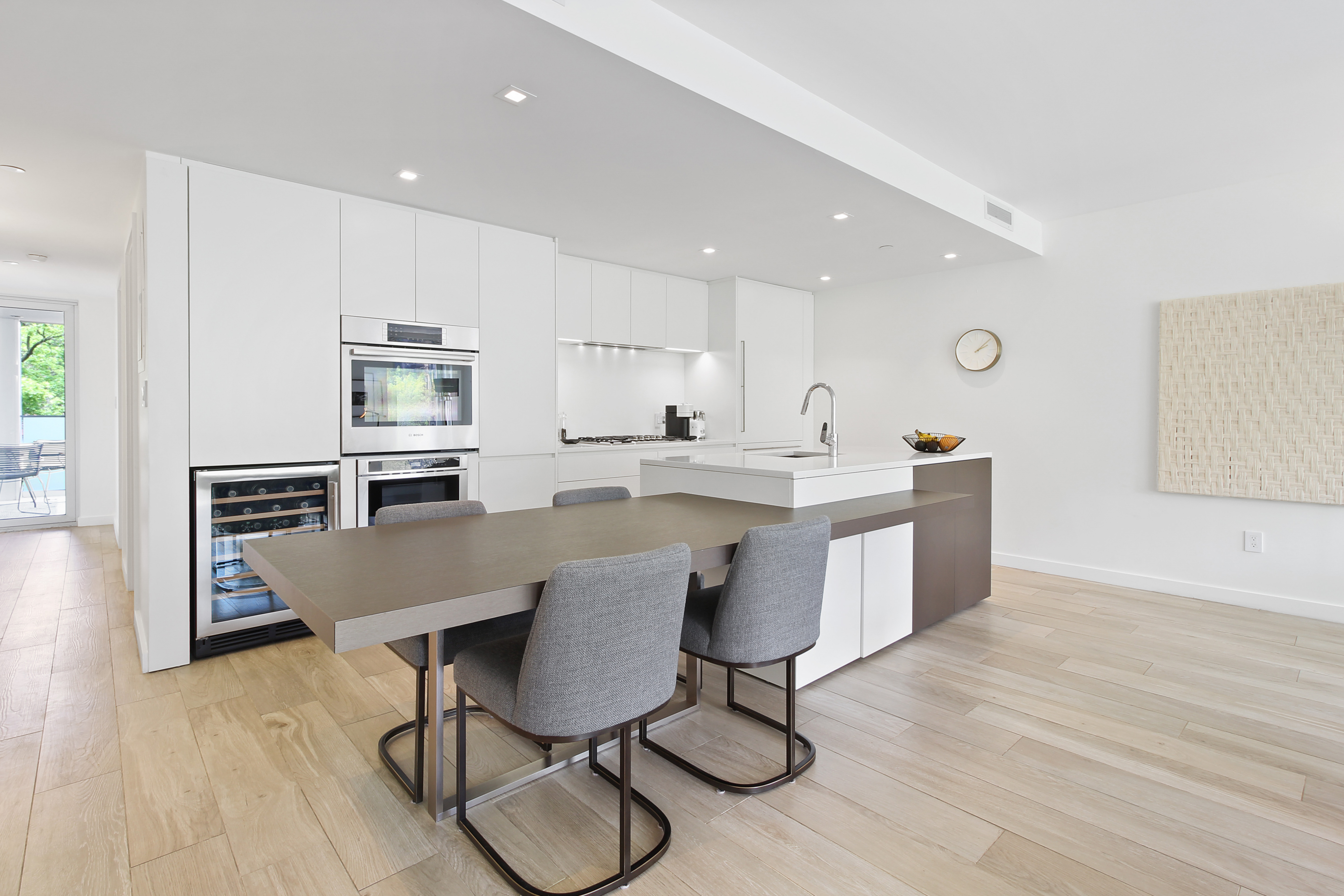 136 West Houston Street, Unit 4 Manhattan, NY 10012 - Photo 3 of 14 a kitchen with granite countertop a table chairs microwave and cabinets