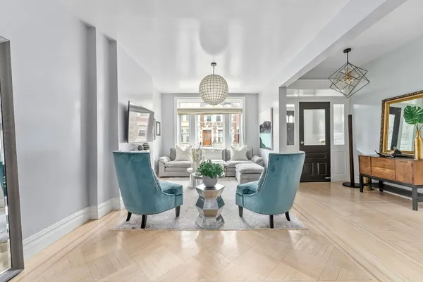 a living room with furniture a chandelier and a window
