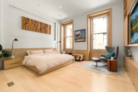 a spacious bedroom with a bed couch and a window