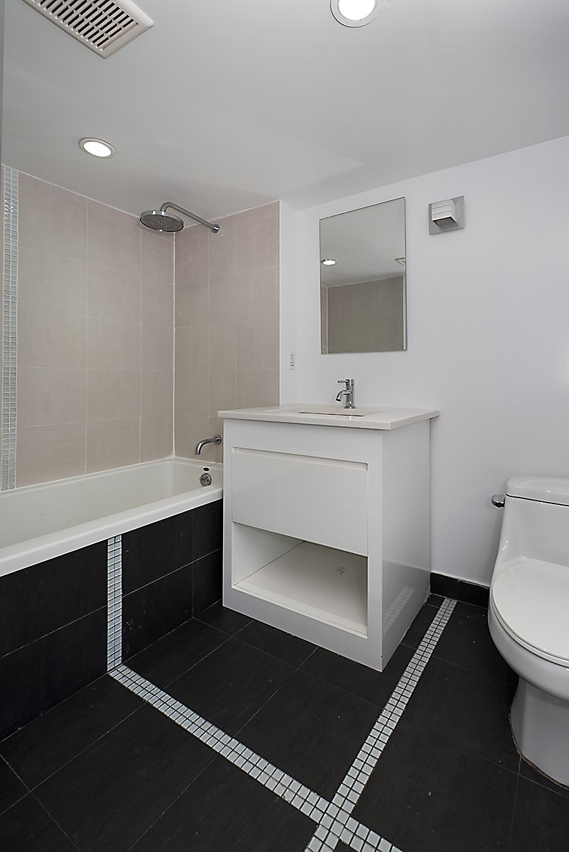 105 Grand Avenue, Unit 3B Brooklyn, NY 11205 - Photo 9 of 10 a bathroom with a sink toilet a mirror and shower