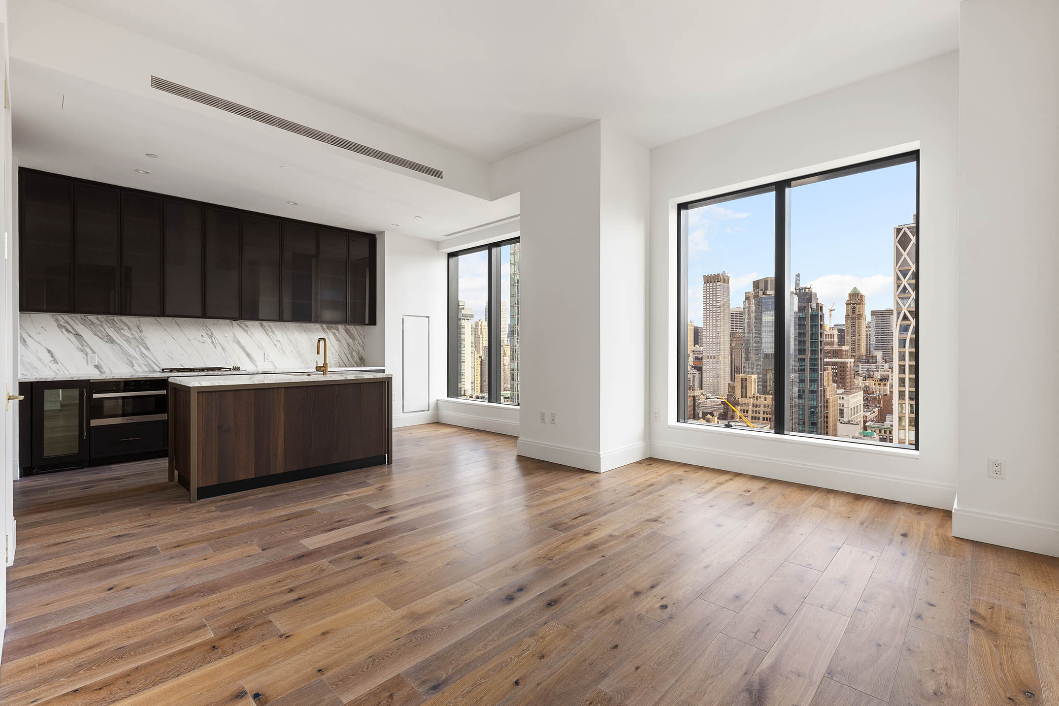 a large white kitchen with a large window a oven and a counter space