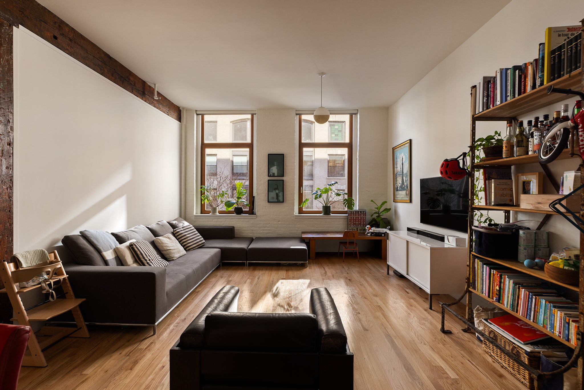 a living room with furniture flat screen tv and a book shelf