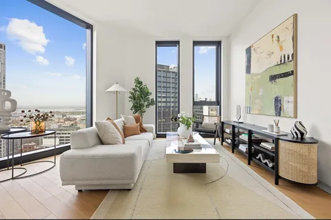 a living room with furniture and floor to ceiling window