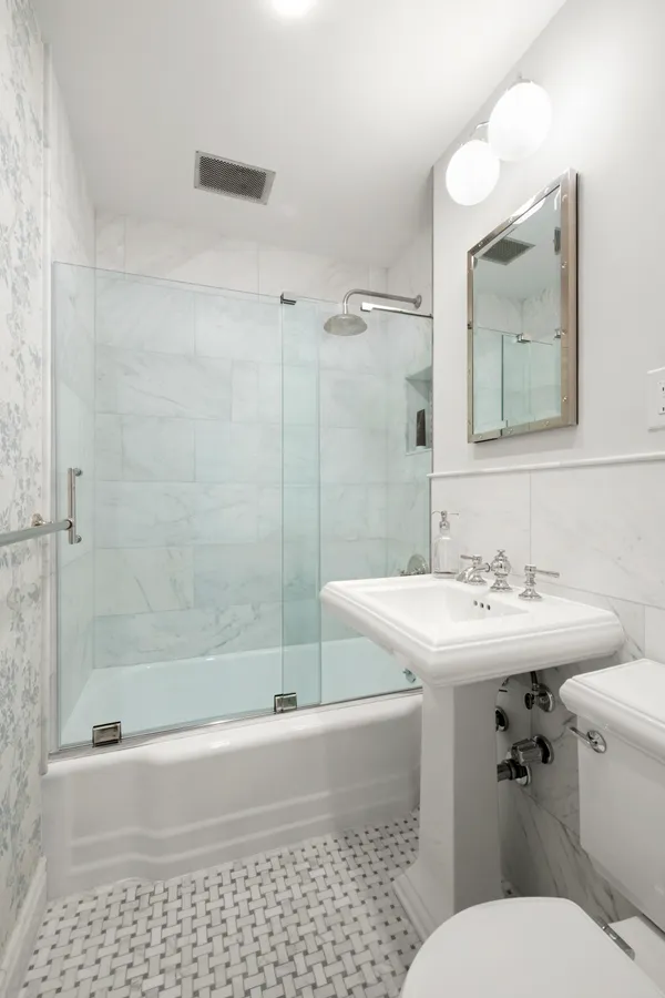 a bathroom with a sink a toilet and shower