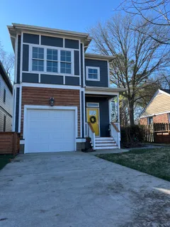 a view of a house with a yard and large tree