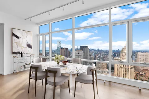 a dining room with furniture water view and large windows
