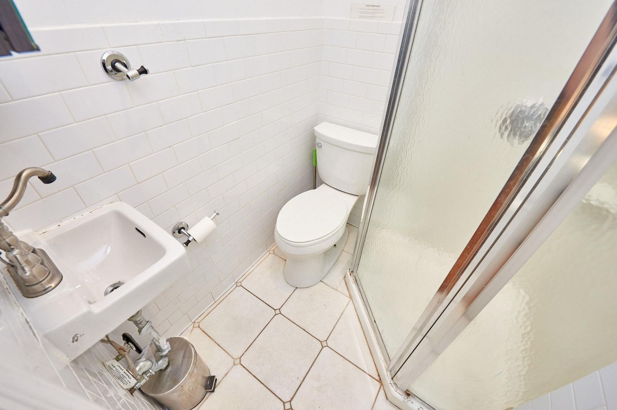 170 Elizabeth Street, Unit 1 Manhattan, NY 10012 - Photo 11 of 16 a white toilet sitting next to a bathroom sink