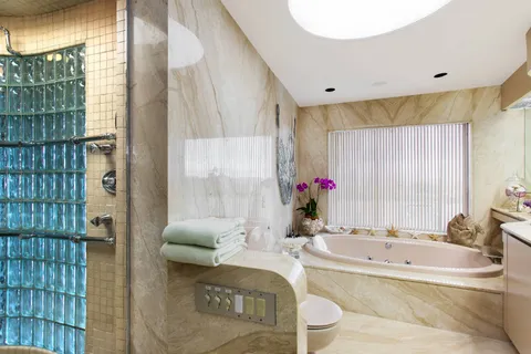 a bathroom with a granite countertop tub sink and mirror