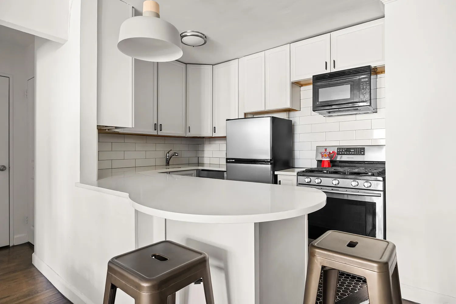 a kitchen with stainless steel appliances a stove microwave and refrigerator