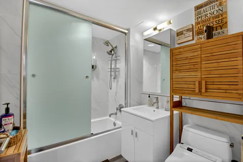 a bathroom with a sink a toilet and shower