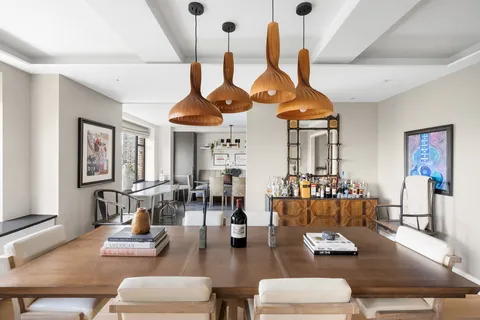 a living room with furniture kitchen view and a chandelier