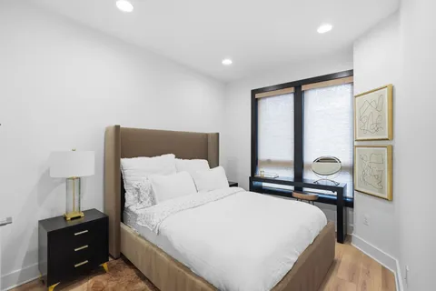 a bedroom with a bed and a lamp with the dresser