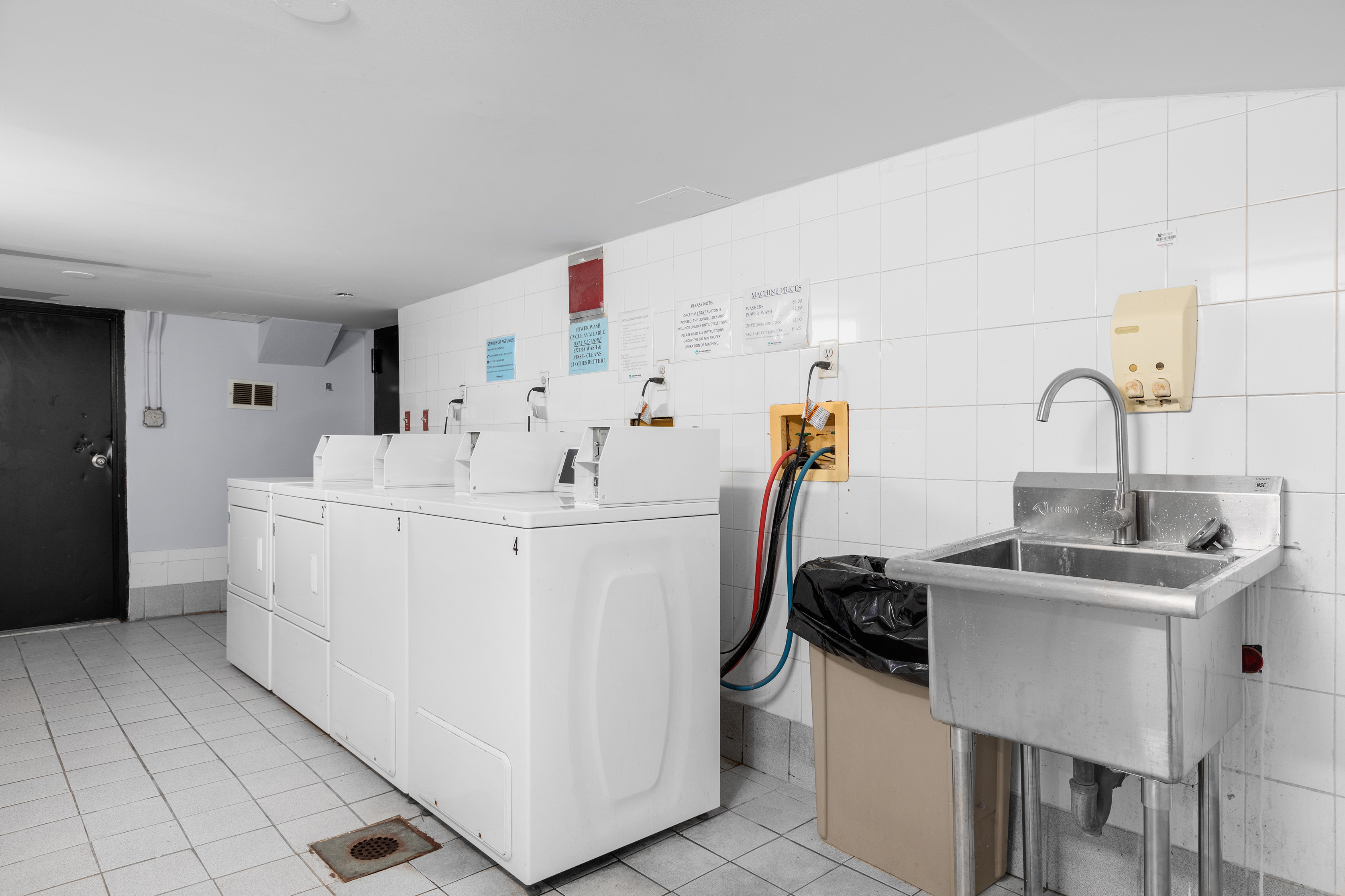 1582 York Avenue, Unit 5B Manhattan, NY 10028 - Photo 9 of 14 a white room with a sink a washer and dryer