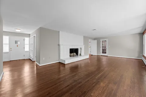a view of a livingroom with wooden floor and a ceiling fan
