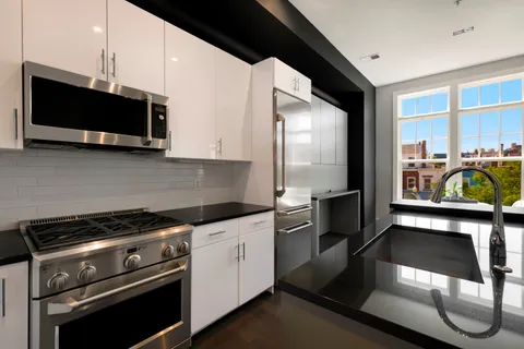 a kitchen with stainless steel appliances a stove microwave and sink