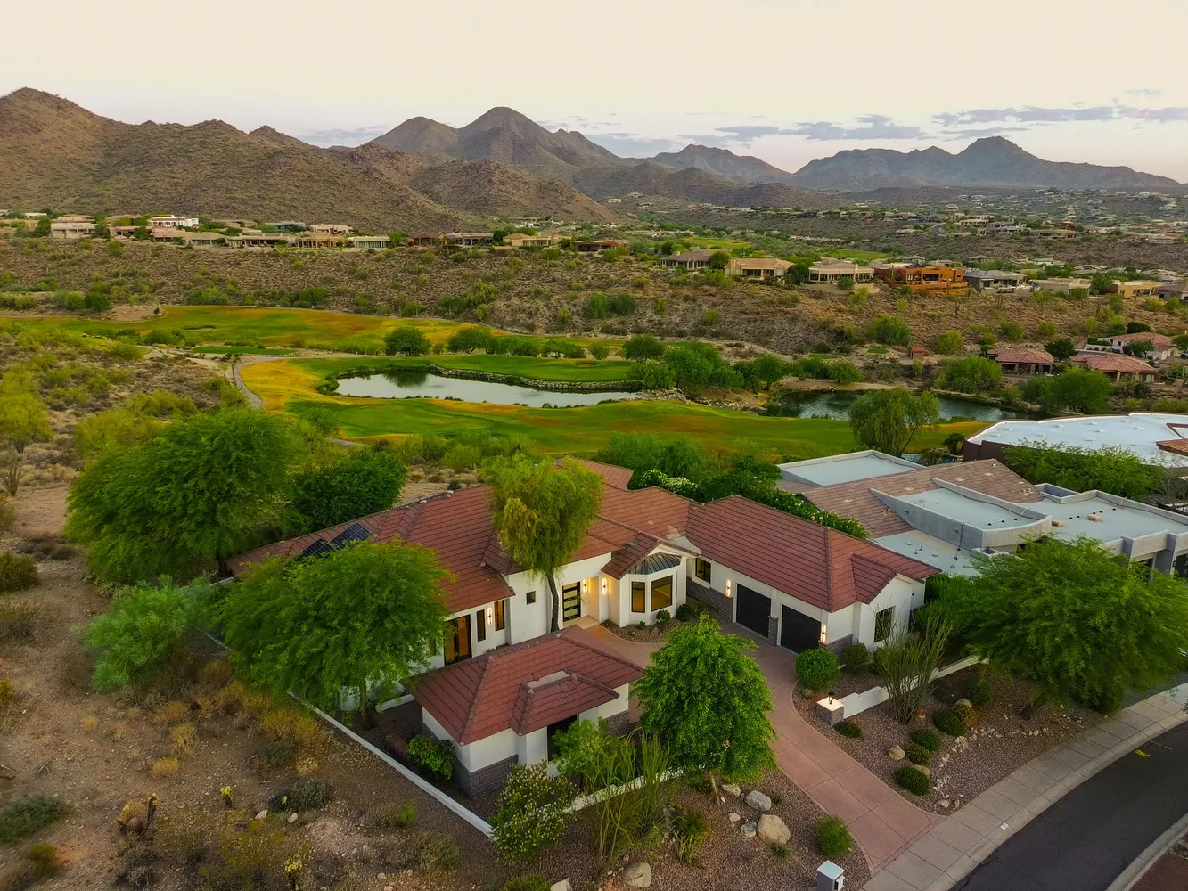an aerial view of residential houses with outdoor space and trees