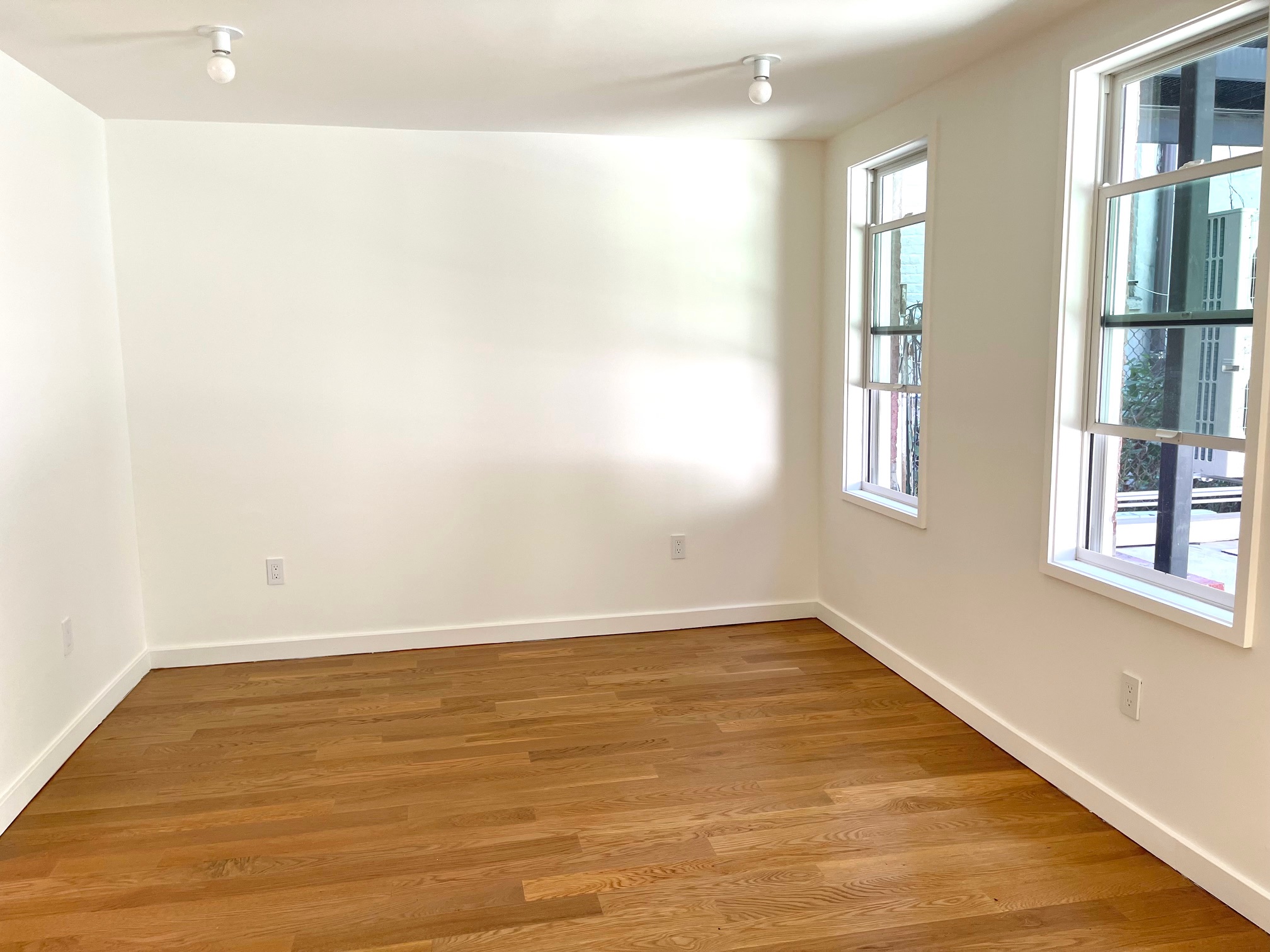 978 Bergen Street, Unit GARDEN Brooklyn, NY 11216 - Photo 4 of 15 an empty room with wooden floor and windows