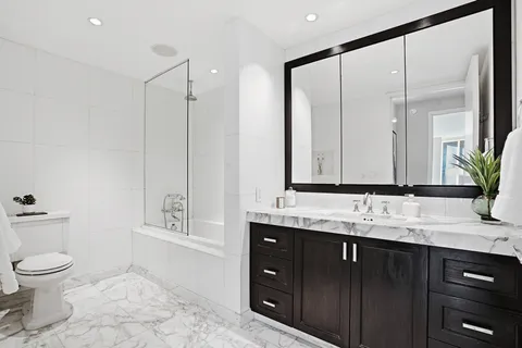 a bathroom with a granite countertop sink toilet and shower