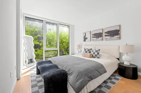 a bedroom with a bed and a large window