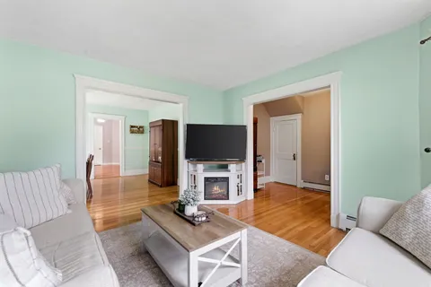 a view of a a dining room with furniture window and wooden floor