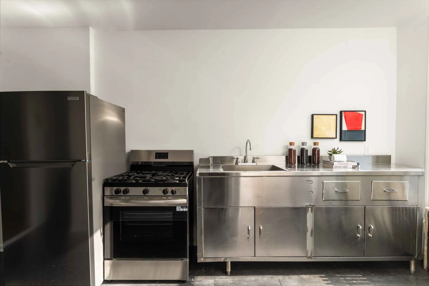 a kitchen with stainless steel appliances granite countertop a refrigerator and a stove