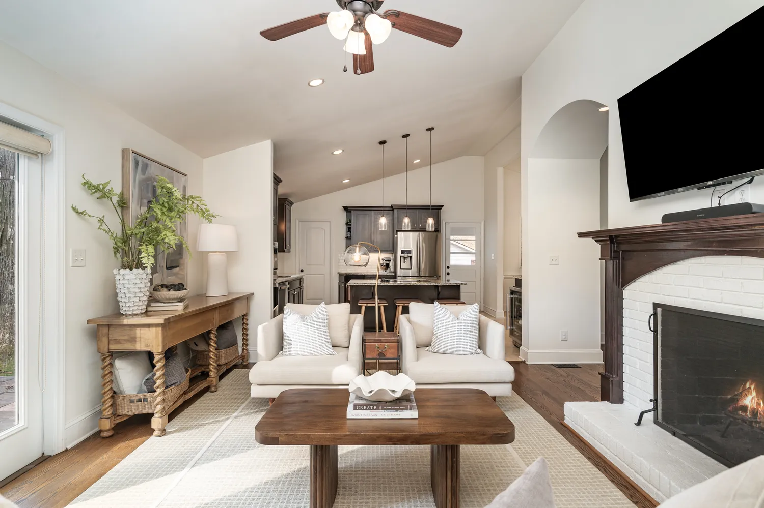 a living room with furniture a fireplace and a flat screen tv
