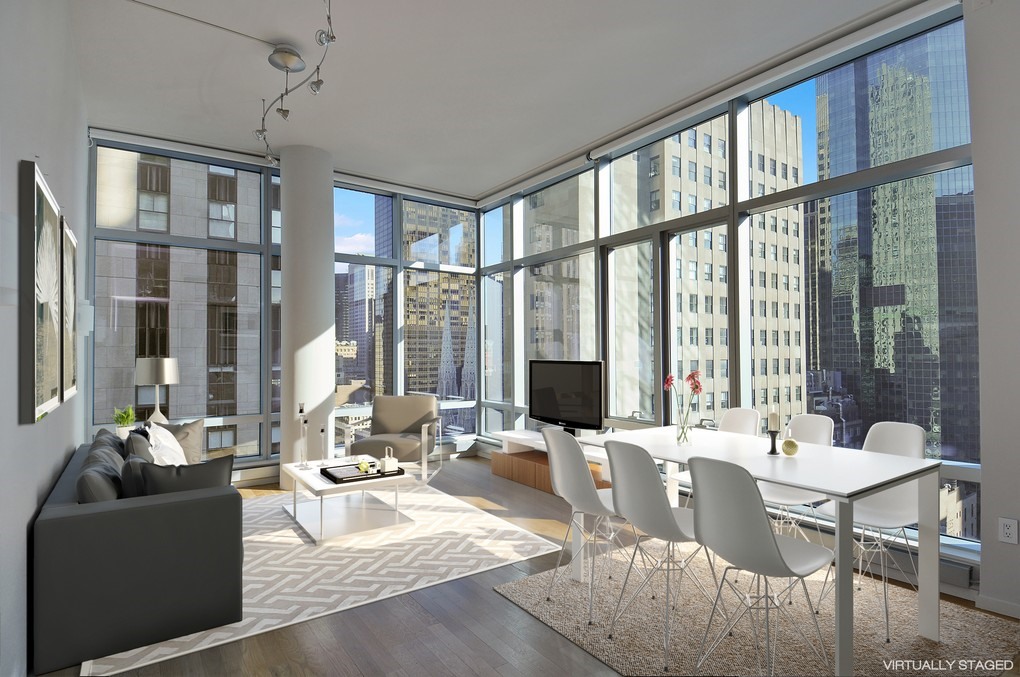18 West 48th Street, Unit 23B Manhattan, NY 10036 - Photo 1 of 5 a living room with furniture and large windows